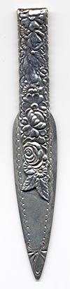 This bookmark was made in the US by Gorham. It is very similar to one from the 1888 catalog. It is marked with the Gorham hallmarks and the catalog number 26. The top blade is full of flowers. The date is 1885 - 1895.