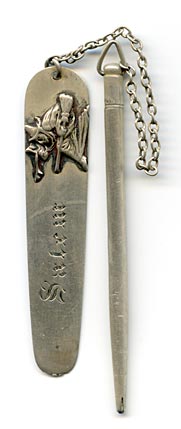 This bookmark was made in the US by Daniel Low and Co. It is comprised of a flat blade connected by chain to a mechanical pencil. It is marked sterling on the top of the pencil and engraved Salem on the blade. The blade also shows the famous Salem witch riding a broom, the trademark of Daniel Low.