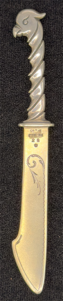 This bookmark was made in the US by Gorham Mfg. Company. It is marked with the manufacturers mark, sterling 28 and a crown (indicating 1879). 28 is the number from the Autumn 1888 catalogue. The top is a figural bird.