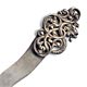 This bookmark depicts a snake entwined in a viney flowery design. It is made of silver and is marked sterling on the back. 