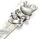  This bookmark was made in the US by an unknown manufacturer. It is marked sterling on the back. This is a clip type bookmark with a baby chick on top of a ribbon. The back is inscribed 1892.  Date is 1892.   