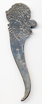 This bookmark was manufactured in the US by Towle Silversmiths. It is marked with the familiar hallmark of the T enclosing a lion along with Sterling and the number 6. On top of the 6 is stamped the number 17. This is a very interesting piece because the front is a very detailed relief of a rose and the back has a scored picture of a woman with a feather hat. The date is 1890 - 1920.