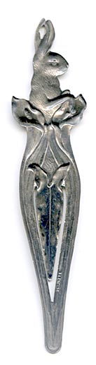 This bookmark was made in the US by an unknown manufacturer. It is marked sterling on the lower outer blade. The top is a rabbit poking his body out of a lily flower. This was most likely an Easter gift. It was sold in the 1910 Shreve catalog. 
