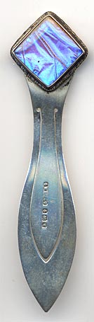 This sterling bookmark was made in Birmingham England in 1921 by G W Lewis as indicated by the hallmarks. The top has a glass enclosed piece of a butterfly wing in iridescent blue. It is still quite vibrant after 95+ years.