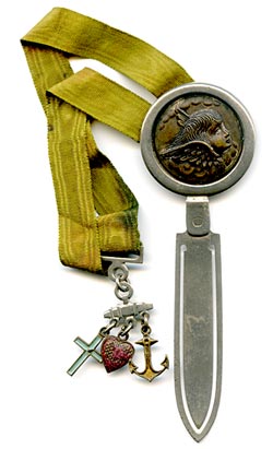 This bookmark was made in Europe around the turn of the 20th century. It is silver plate with a bronze medallion of a cherub. Attached to the top is a yellow-green silk ribbon with three brass and enamel charms attached. The cross, heart and anchor represent faith, hope and charity.