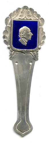 This bookmark was made in Denmark by Eiler & Marløe of Copenhagen. The back is hallmarked 830s and E & M. The top is a detailed bust of Hans Christian Andersen surrounded by a shield of deep blue enamel.