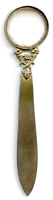 This bookmark was made in France. The top is a magnifying glass held up by two horns of fruit. The top blade has 3 bees (a symbol of Napoleon). It has two French hallmarks on the side of the glass. 