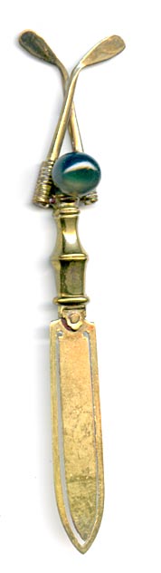 This bookmark was made in France. It has two crossed golf clubs with an agate marble between them on the top.