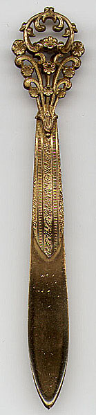 This bookmark was made in France by an unknown manufacturer. It is made of bronze d'ore and is unmarked. The top is a 3D floral pattern. The date is probably 1910 - 1920.