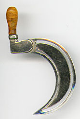  This bookmark has an amber handle and silver plate blades. It is in the shape of a sickle. It was probably made in a European country about 1920 - 1930.   