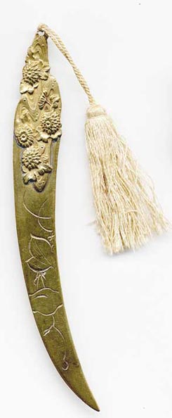  This bookmark was made in Japan. It is brass and has a detailed relief of flowers on the top as well as a silk tassel. There is only one blade so it was probably used as a paper knife as well. The date is 1900 - 1910. 